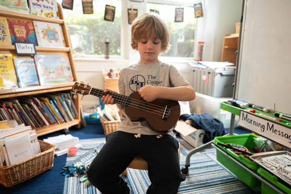 student playing on guitar