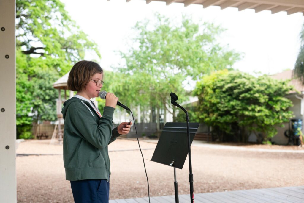 student on stage with microphone outside