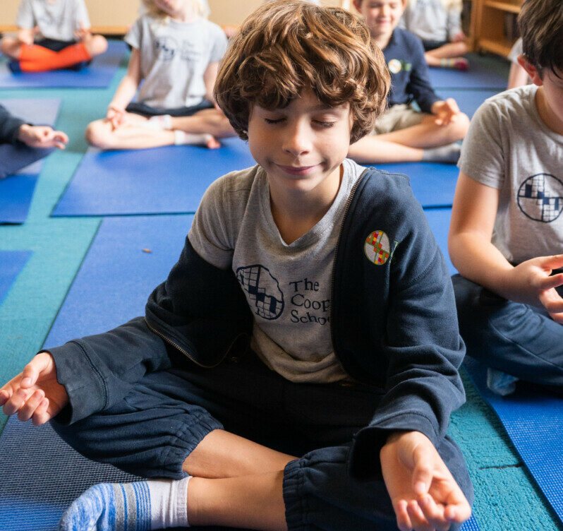 student meditating in yoga classroom