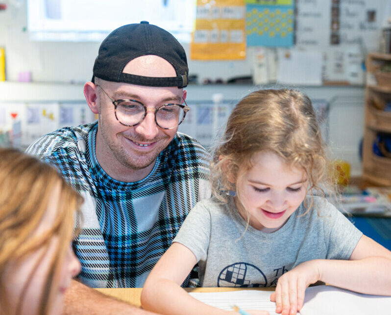 teacher with student at desk