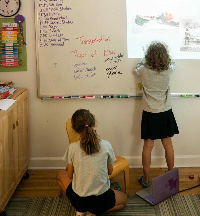 2 students in classroom by board