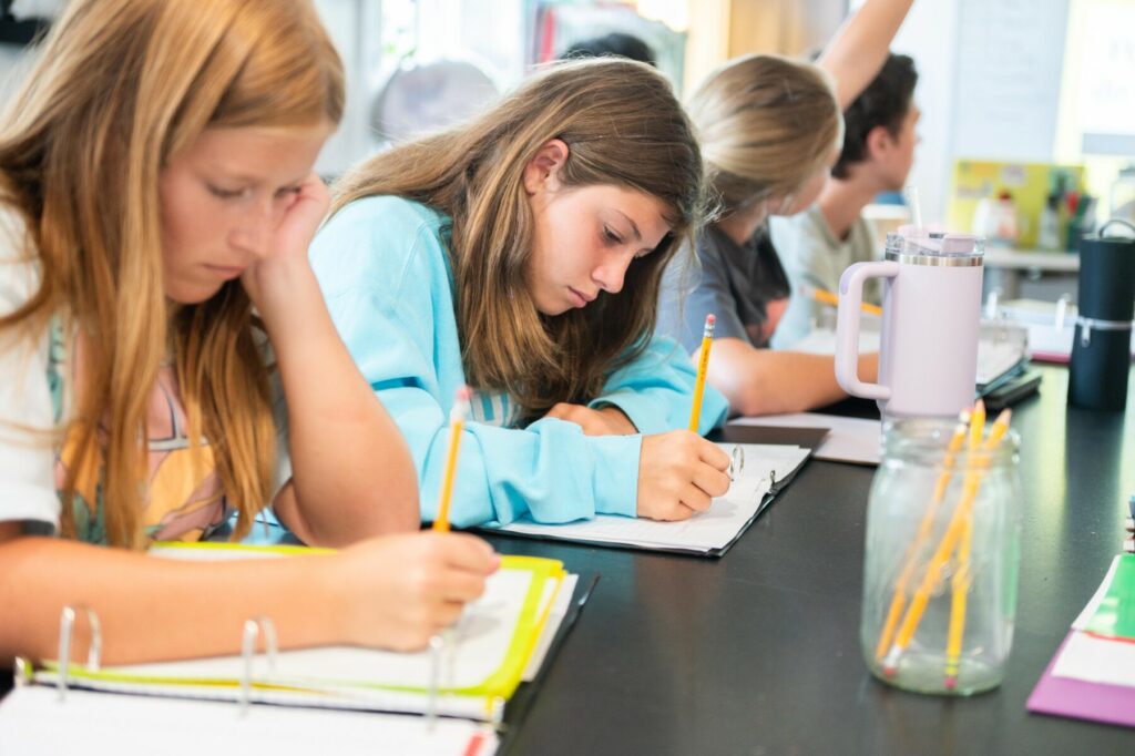 female students writing in book