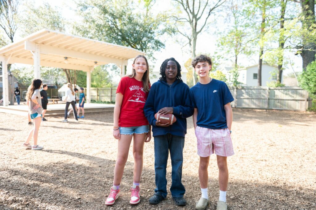 3 students in yard standing together